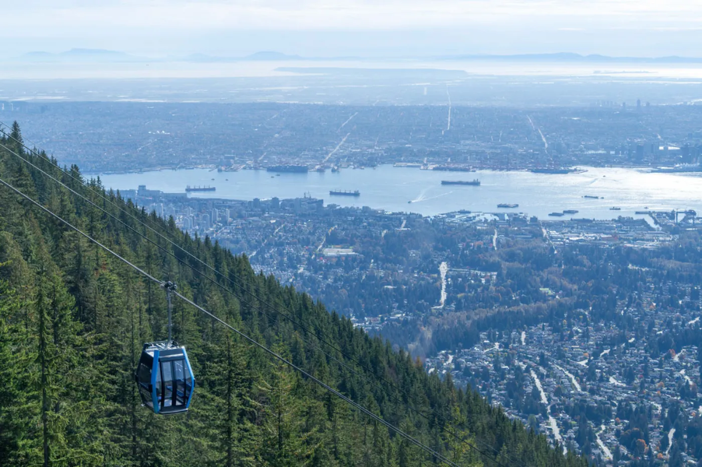 Blue Grouse Gondola ascending Grouse Mountain with Vancouver visible in the background. Image courtesy of Grouse Mountain